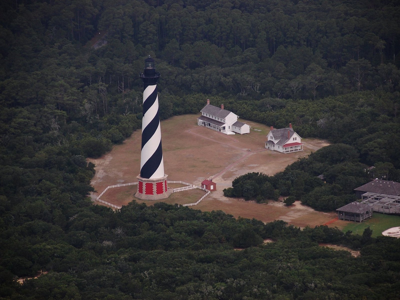 Aerial view of the black and white spiral Cape Hatteras Lighthouse and light station grounds in Buxton