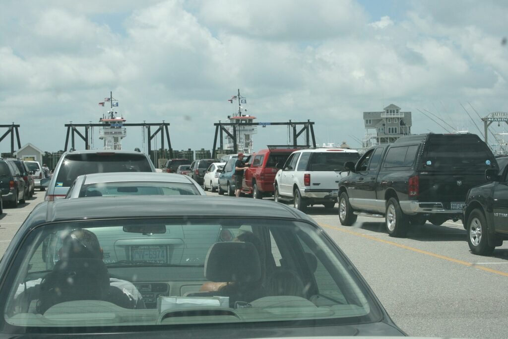 Cars lined up to board the Hatteras to Ocracoke ferry, boats waiting in their slips ahead